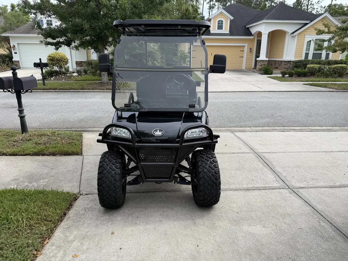 Lifted cart with knobby all-terrain tires and a front brush guard